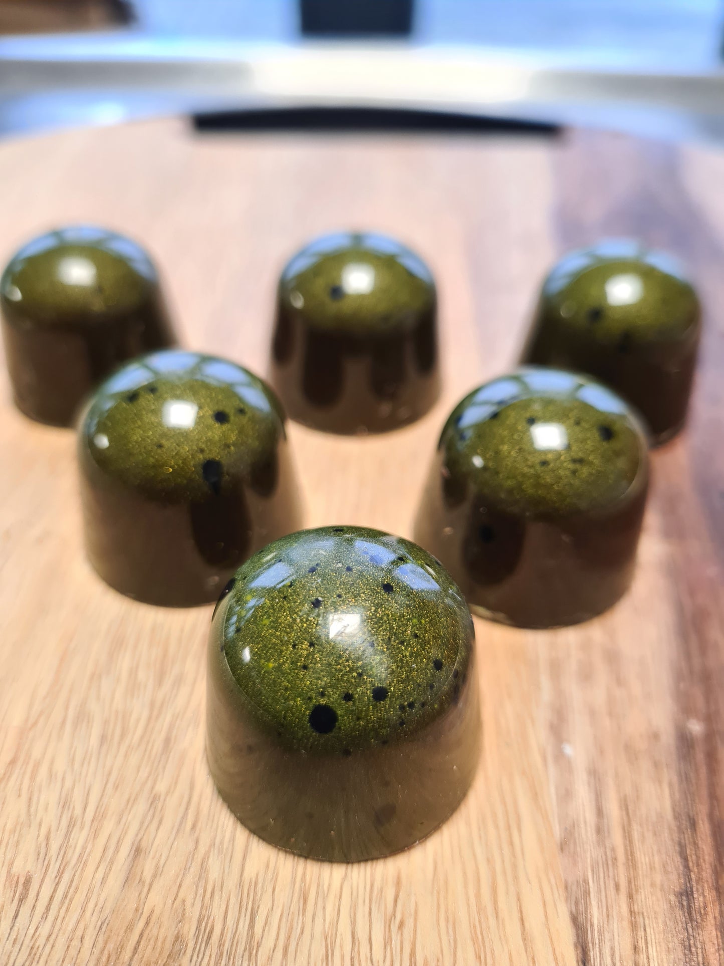 Luxe handgemaakte bonbon van pure Belgische chocolade met een frisse vulling van mango en passievrucht, voorzien van een uniek kleurrijk design.